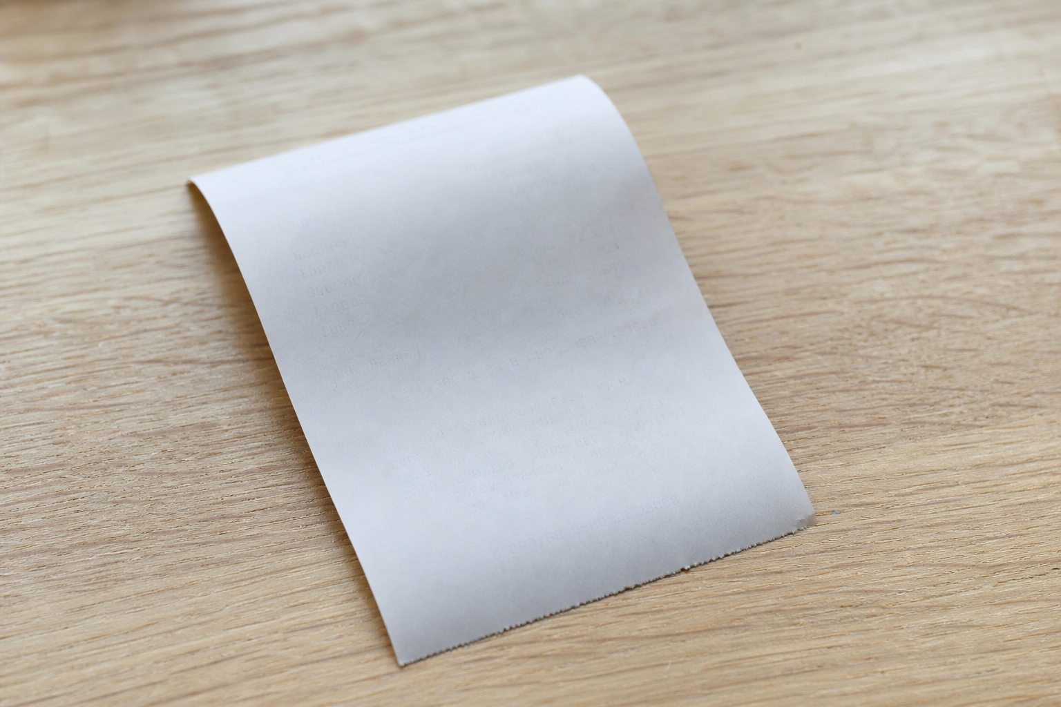 Ticket de caisse en papier thermique dont le texte imprimé est presque entièrement effacé